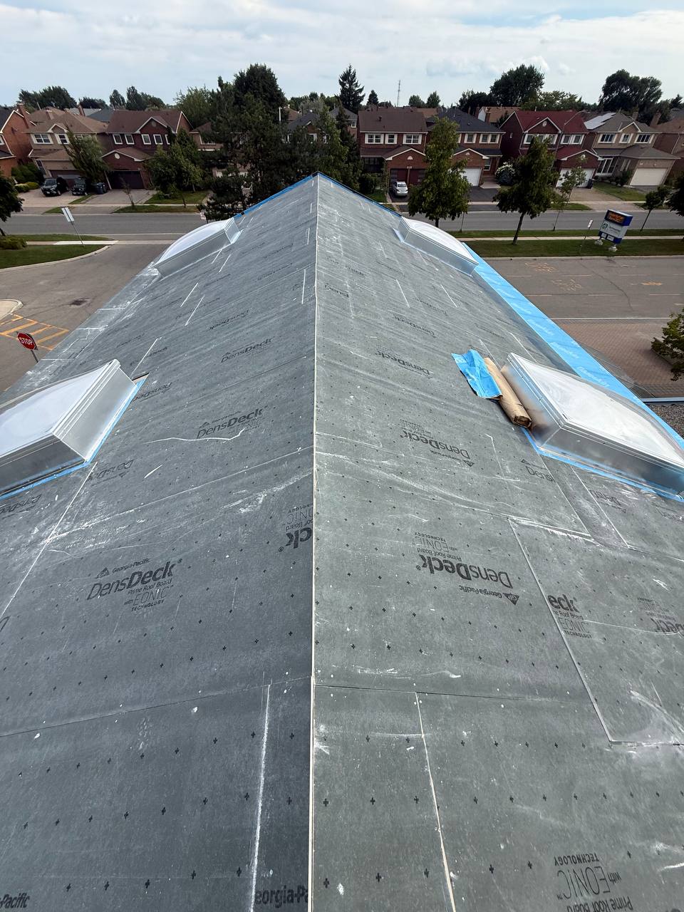 Roofing work along a ridge with skylights and weather protection